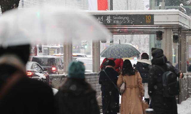 12일 예고 없이 내린 폭설에 시민들이 교통대란을 피해 급히 지하철역으로 발길을 옮기고 있다. 연합뉴스