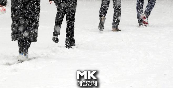 12일 오후 함박눈이 쏟아지는 가운데 명동거리에서 시민들이 발걸음을 재촉하고 있다.