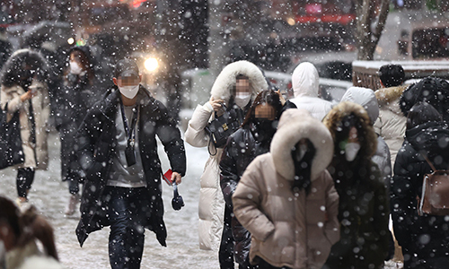 눈이 내린 12일 저녁 서울 강남역 인근에서 시민들이 퇴근길을 재촉하고 있다. 연합뉴스
