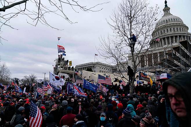 ⓒAFP PHOTO1월6일 트럼프 대통령의 대선 불복 연설을 듣고 난 뒤, 트럼프 지지자들이 워싱턴 D.C. 의사당으로 몰려갔다. 태극기도 눈에 띈다.