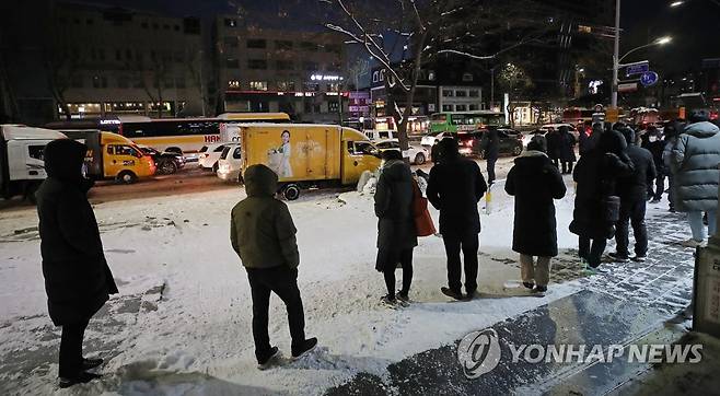 지난 7일 오전 눈 위에서 버스를 기다리는 시민들 [연합뉴스 자료사진]