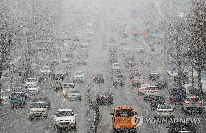 퇴근길 괜찮을까? (수원=연합뉴스) 홍기원 기자 = 많은 눈이 내린 12일 오후 경기도 수원시 팔달구 경수대로에서 차량이 서행하고 있다. 2021.1.12 xanadu@yna.co.kr