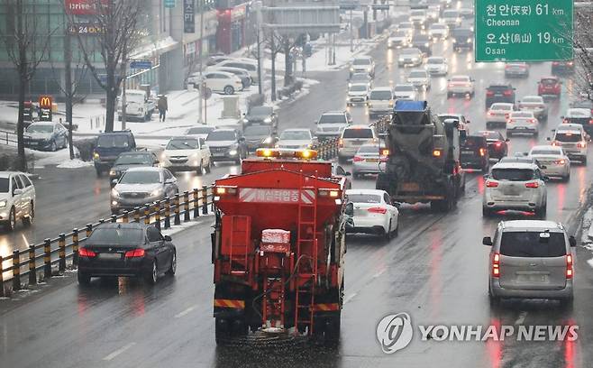 퇴근길 교통대란을 막아라 (수원=연합뉴스) 홍기원 기자 = 많은 눈이 내린 12일 오후 경기도 수원시 팔달구 경수대로에서 제설차가 도로에 염화칼슘을 살포하고 있다. 2021.1.12 xanadu@yna.co.kr