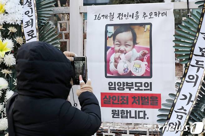 12일 오전 서울 양천구 남부지방검찰청 앞에 마련된 정인이를 위한 추모 공간에서 한 시민이 정인이의 모습을 휴대전화 카메라에 담고 있다. 2021.1.12/뉴스1 © News1 민경석 기자