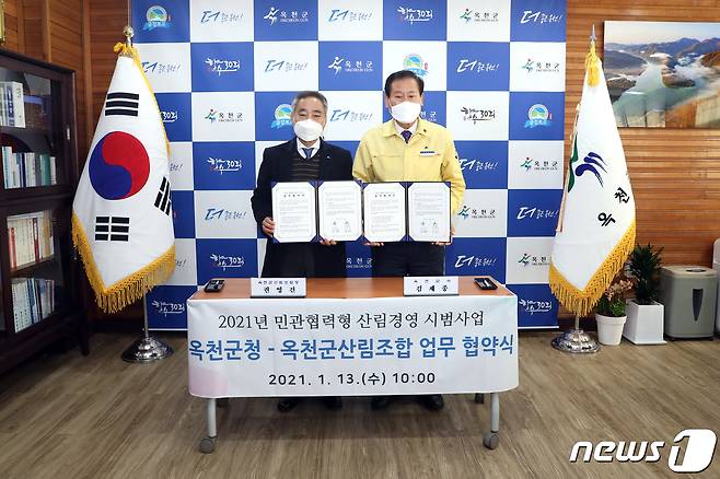 13일 김재종 옥천군수(오른쪽)와 권영건 군산림조합장이 업무 협약을 맺고 있다. (옥천군 제공)© 뉴스1