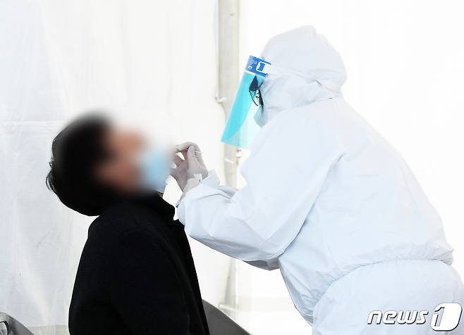 13일 경기도 수원시 팔달구 경기도청에서 공무원이 신종 코로나바이러스 감염증(코로나19) 검사를 받고 있다. 경기도는 오는 19일까지 일주일간 도청 및 산하공공기관 전직원 1만2000여명에 대해 선제적인 코로나19 전수조사를 실시한다. 최근 도 소방재난본부와 파주, 광명시 등 공공기관에서 확진자가 잇따라 발생함에 따라 방역행정에 차질이 빚어질 수있다는 판단에서다. 2021.1.13/뉴스1 © News1 이재명 기자