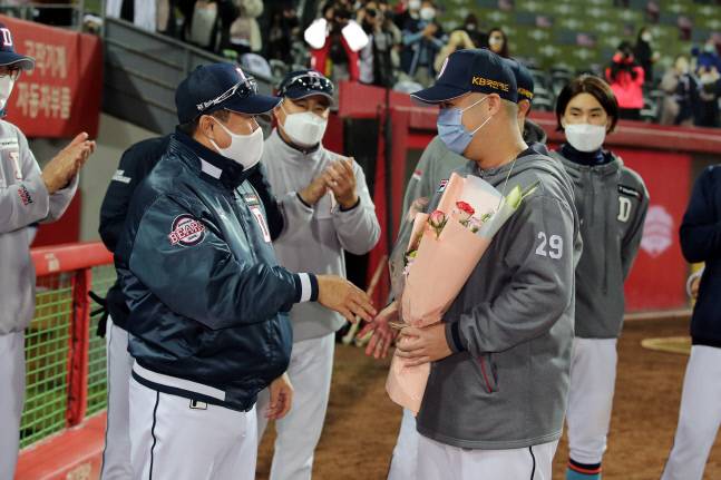 두산 김태형 감독(왼쪽)이 29일 광주-KIA 챔피언스필드에서 열린 KIA와 원정경기에서 시즌 10승째를 달성한 유희관에게 꽃다발을 건네고 있다. 제공=두산 베어스