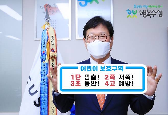 ▲ 김대권 수성구청장이 ‘1단 멈춤, 2쪽 저쪽, 3초 동안, 4고 예방’ 구호 피켓을 들고 ‘어린이 교통안전 릴레이 챌린지’에 동참했다. 수성구청 제공