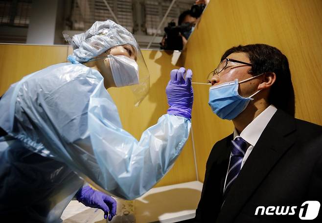 일본 도쿄도 나리타 국제공항의 한 선별진료소에서 의료진이 코로나19 진단검사를 실시하고 있다. © 로이터=뉴스1