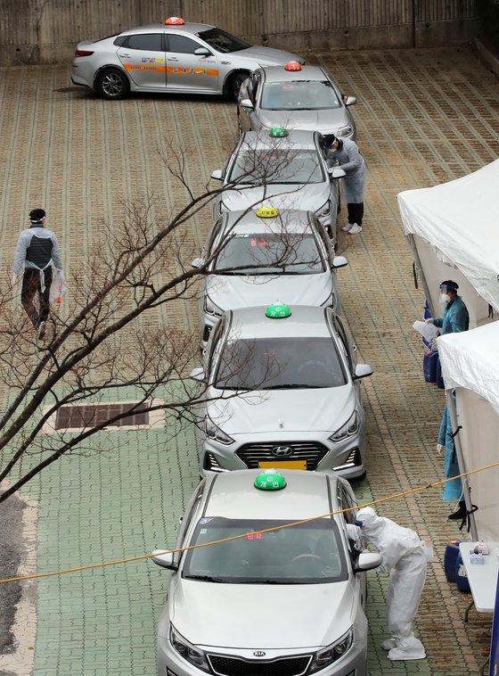 지난 11일 부산지역 택시 기사들이 연제구 아시아드주경기장 주차장에 마련된 이동 선별검사소에서 드라이브스루 방식으로 코로나19 진단검사를 받고 있다. 송봉근 기자