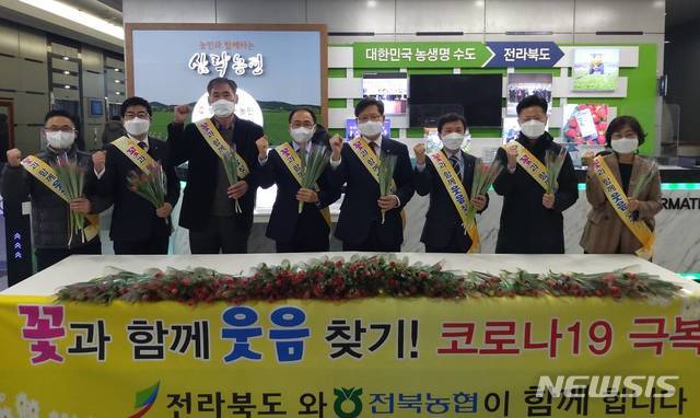 [전주=뉴시스]윤난슬 기자 = 전북도와 전북농협은 14일 전북도청에서 출근하는 직원들에게 꽃 한 송이를 나눠주며 화훼 소비 촉진을 위한 '꽃과 함께 웃음 참기' 캠페인을 펼쳤다고 밝혔다.(사진=전북농협 제공)