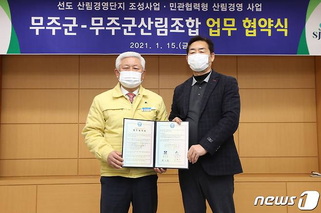 15일 황인홍 전북 무주군수(왼쪽)가 박철수 무주산림조합장과 업무협약을 맺고 있다.(무주군제공)2021.1.15/뉴스1