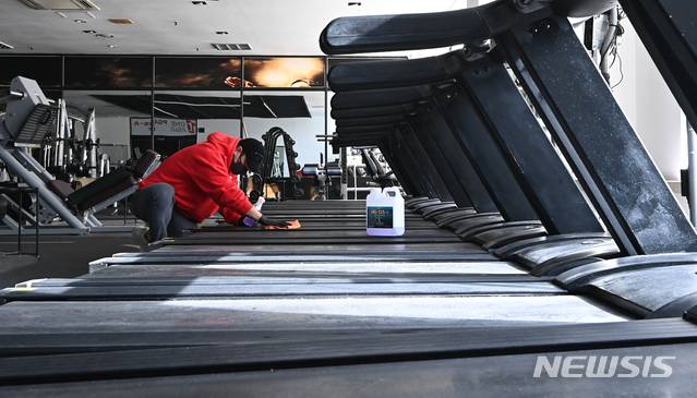 [용인=뉴시스] 김종택기자 = 14일 오후 경기도 용인시 수지구 한 휘트니스센터에서 관계자가 운동기구를 소독하며 영업준비를 하고 있다. 정부는 사회적 거리두기 수도권 2.5단계, 비수도권 2단계 조치 종료를 앞두고 헬스장 등 실내체육시설 집합금지를 완화하되 5인 이상 사적모임 금지 조치는 유지할 가능성이 높다고 밝혔다. 2021.01.14.jtk@newsis.com