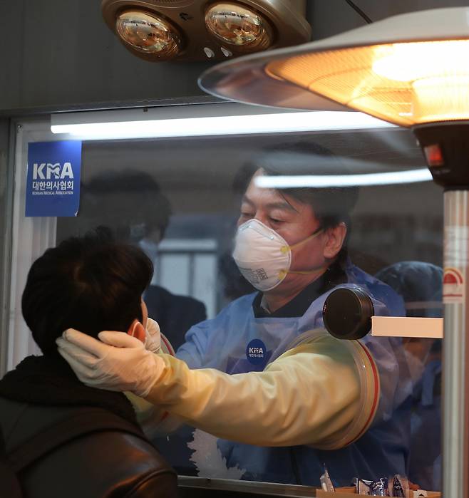 안철수 국민의당 대표가 1월15일 의료봉사에 나서며 서울시청 앞 광장에 마련된 임시 선별검사소에서 시민들의 검체채취를 하고 있다. ⓒ연합뉴스
