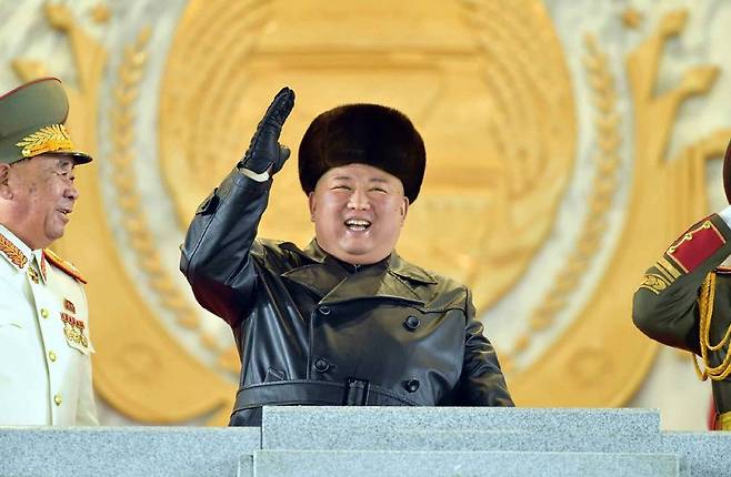 김정은 북한 국무위원장이 14일 저녁 평양 김일성광장에서 열린 노동당8차대회 기념 열병식에서 참석자들에게 손은 들어 인사하고 있다./노동신문/뉴스1