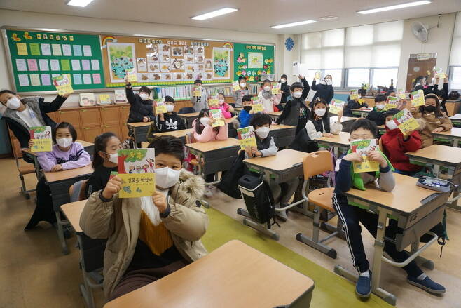 지난 12일 오전, 군산푸른솔초등학교 2학년 4반 어린이들이 자신들이 쓴 시를 엮은 어린이시집 <감꽃을 먹었다>를 들고 있다. 송숙 제공