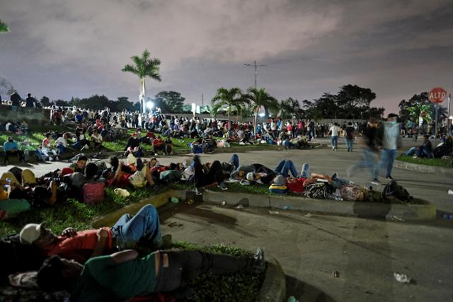 온두라스 산페드로술라의 버스정류장 앞에서 14일 온두라스인들이 미국행을 시도하는 중남이 이민자 행렬의 출발을 기다리며 휴식을 취하고 있다. 산페드로술라=로이터 연합뉴스