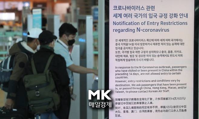 인천공항 내 코로나바이러스 관련 세계 여러 국가의 입국 규정 강화에 대한 안내를 탑승객이 보고 있다. / 사진 = 매경 DB