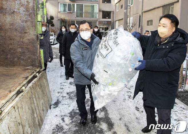 (서울=뉴스1) = 홍정기 환경부차관이 한범덕 청주시장과 함께 8일 오전 충북 청주시 소재 아파트를 방문, 별도 배출된 투명페트병을 전용 수거 차량에 싣고 있다. (환경부 제공) 2021.1.8/뉴스1