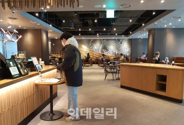 카페 매장 내 취식이 제한적으로 다시 재개한 첫날 18일 서울 용산구 한 스타벅스커피 매장 내부 모습. 평소보다 좌석은 듬성듬성 배치돼 있고 남은 테이블과 의자는 한쪽 벽면에 쌓아져 있다.(사진=김범준 기자)