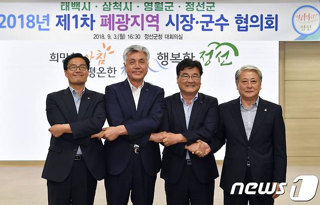 류태호 태백시장(왼쪽부터), 최승준 정선군수, 최명서 영월군수, 김양호 삼척시장이 3일 강원 정선군청 대회의실에서 열린 2018 제1차 폐광지역 시장군수 협의회에서 손을 잡고 기념촬영을 하고 있다. (정선군청 제공) 2018.9.3/뉴스1 © News1