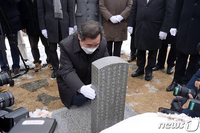이낙연 더불어민주당 대표가 18일 오후 광주 북구 운정동 국립5·18민주묘지에서 참배를 마친 뒤 윤상원 열사 묘비를 잡고 무릎을 꿇고 있다.2021.1.18/뉴스1 © News1 정다움 기자