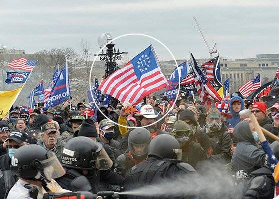 6일 미국 위싱턴 의사당으로 난입하려던 시위대 중 한 명이 성조기의 50개 별 대신 ‘Ⅲ’이라고 적힌 ‘쓰리 퍼센터’ 깃발을 들고 있다. [AFP=연합뉴스]