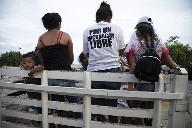 엘테레로 자경단원들이 지난 13일(현지시간) 자녀들과 함께 멕시코 엘테레로 마을 외곽에서 순찰을 돌고 있다. 이들이 입은 하얀 티셔츠에는 ‘미초아칸의 자유를 위해’(POR UN MICHOACAN LIBRE)라는 문구가 적혀 있다. 엘테레로|AP연합뉴스