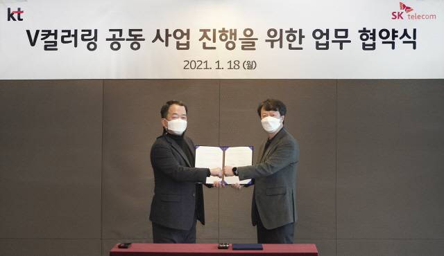 한명진(왼쪽) SK텔레콤 구독형 상품 CO장과 박현진 KT 커스터머전략본부장이 18일 서울 중구 을지로 SKT 사옥에서 V 컬러링 공동 서비스를 위한 협약을 체결한 뒤 악수하고 있다. /SKT