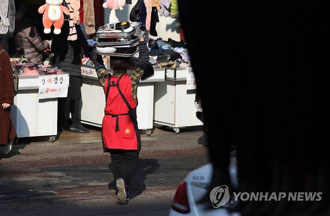 '코로나19로 어려움 겪는 소상공인들' 지난 12월 서울 중구 남대문 시장서 한 음식점 종업원이 음식을 배달하는 모습 [서울=연합뉴스 자료사진]