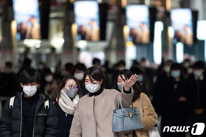 지난 13일 일본 도쿄 시나가와역 구내를 지나가는 시민들이 마스크를 착용하고 있다. © AFP=뉴스1