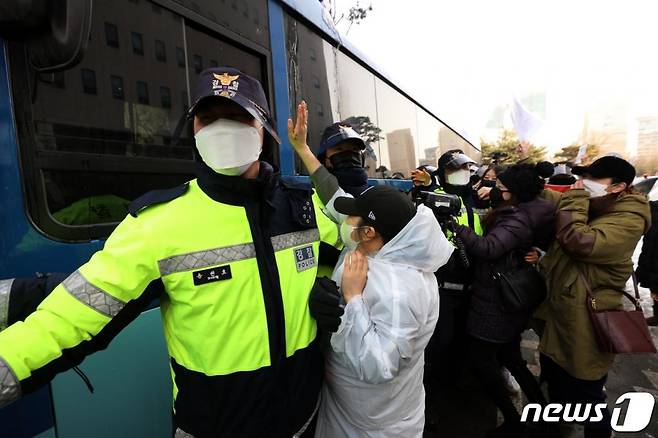 (서울=뉴스1) 이승배 기자 = 정인양을 입양한 후 수개월간 학대해 사망에 이르게 한 혐의를 받는 양부모에 대한 첫 재판이 열린 13일 오전 서울 양천구 서울남부지방법원에서 양모가 탄 것으로 추정되는 호송차가 나오자 시민들이 분노를 표출하고 있다. 2021.1.13/뉴스1