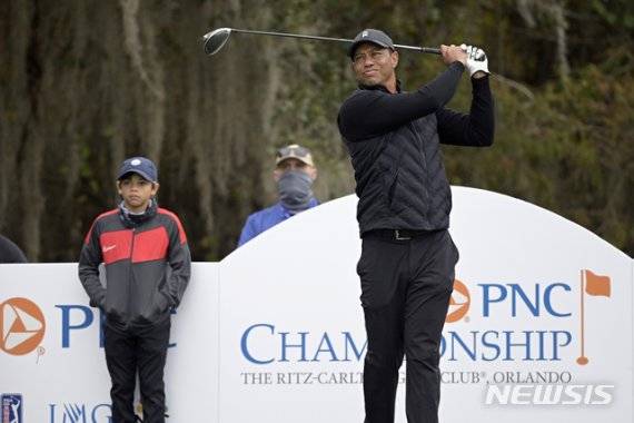 지난해 12월 17일(이하 현지시간) 미국 플로리다주 올랜도의 리츠칼턴 골프장에서 열린 '부자(父子) 골프 대회 PNC 챔피언십' 연습 라운드 12번홀에서 아들 찰리가 지켜보는 가운데 티샷을 날리고 있는 타이거 우즈. 그는 이 대회를 마친 뒤 허리 부상이 재발, 최근 다섯번째 수술대에 올랐다고 소셜 미디어를 통해 밝혔다. /사진=뉴시스