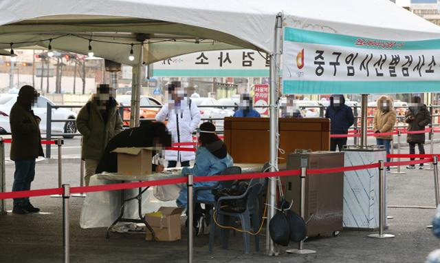 국내 코로나19 첫 환자가 나온 지 꼭 1년째 되는 날인 20일 오전 서울역광장에 마련된 임시선별검사소 앞에서 시민들이 줄 서 기다리고 있다. 연합뉴스