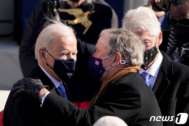 조지 W 부시 전 대통령과 빌 클린턴 전 대통령이 바이든 대통령과 환담을 나누고 있다. © 로이터=뉴스1
