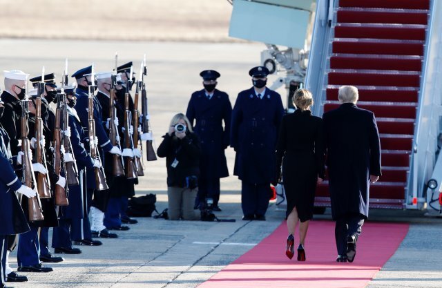 도널드 트럼프 전 대통령과 영부인 멜라니 아 트럼프가 앤드류스 공군 기지에서 에어 포스 원에 탑승하면서 군 의장대의 인사를 받고 있다. AP 뉴시스