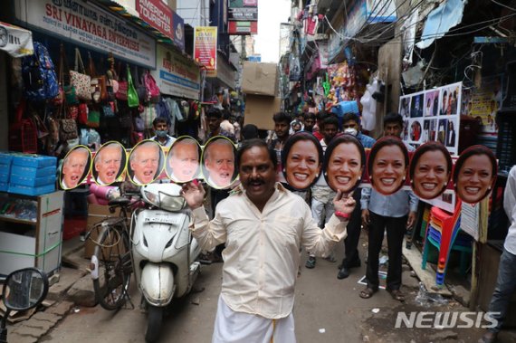 19일(현지시간) 인도 첸나이에서 한 남성이 조 바이든 미국 대통령 당선인과 카멀라 해리스 부통령 당선인의 얼굴 사진을 이어붙여 머리 뒤에 들고 거리를 걷고 있다. /사진=뉴시스화상