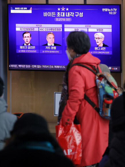 21일 서울역에서 시민들이 조 바이든 미국 대통령 취임 관련 뉴스를 보고 있다. 연합뉴스