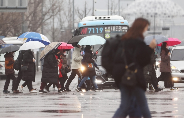 21일 오후 겨울비 내리는 광화문 네거리에 시민들이 지나고 있다/연합뉴스