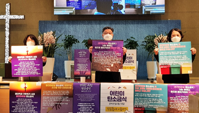 이광섭 기독교환경교육센터 살림 공동대표(가운데)가 21일 서울 동대문구 전농교회에서 열린 ‘경건한 40일 탄소금식 캠페인 준비토크 및 자료나눔회’에서 캠페인 포스터를 들어 보이고 있다. 살림 제공