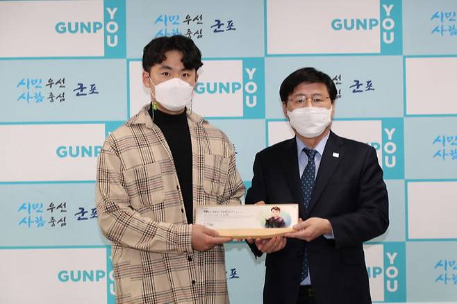 한대희(오른쪽)&nbsp;군포시장이 화재 현장에서 주민을 구한 사다리차 기사 한상훈씨에게 감사패를 건넨 뒤 기념촬영을 하고 있다. 군포시 제공