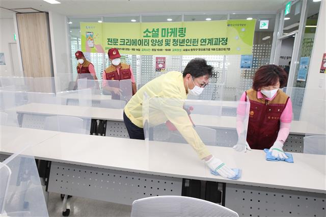 이창우(왼쪽) 서울 동작구청장이 ‘어르신행복주식회사’ 소속 어르신들과 함께 건물 방역 작업을 하고 있다.동작구 제공