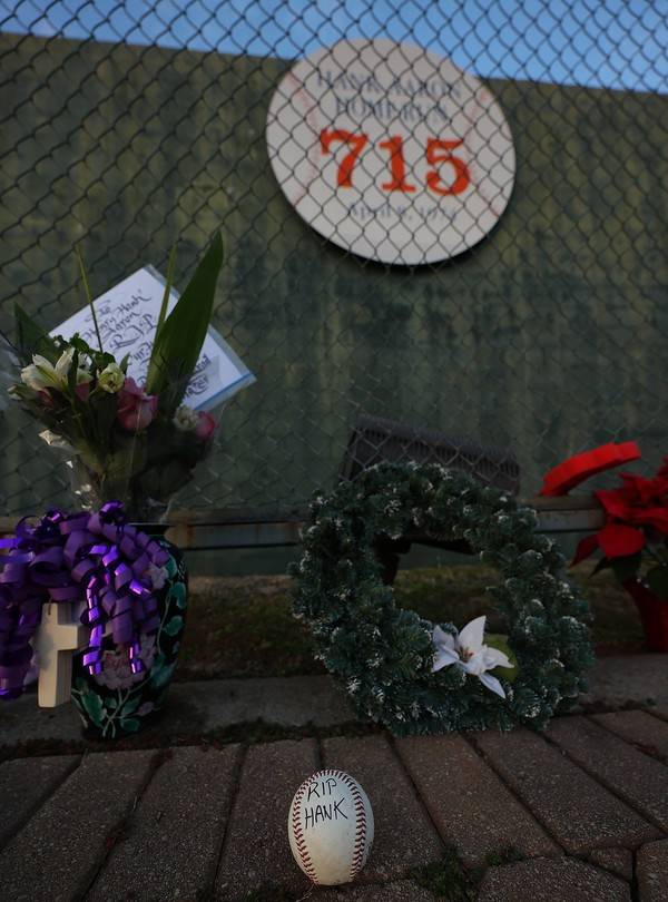 ATLANTA, GEORGIA - JANUARY 22: Fans pay tribute after the death of MLB Hall of Famer&nbsp;Hank&nbsp;Aaron at the marker where Aaron broke the record and hit his 715th homer at the former site of Atlanta?Fulton County Stadium on January 22, 2021 in Atlanta, Georgia. Kevin C. Cox/Getty Images/AFP