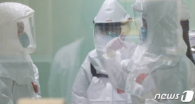 국내에서 신종 코로나바이러스 감염증(코로나19) 확진자가 처음 발생한지 1년째 되는 날인 20일 방호복을 착용한 울산대병원 의료진들이 환자를 돌보기 위해 특수(음압)중환자실로 들어서기 전 이야기를 나누고 있다. 2021.1.20/뉴스1 © News1 윤일지 기자