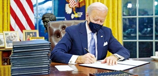 바이든 대통령이 20일(현지시간) 취임 직후 백악관 집무실에서 행정명령에 서명하고 있다. / 사진=AP