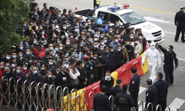 상하이 푸둥 공항의 노동자들이 코로나19 검사를 받기 위해 대기 중인 가운데 경찰과 보안요원들이 경비를 서고 있다. 사진은 이해를 돕기 위함. 연합뉴스