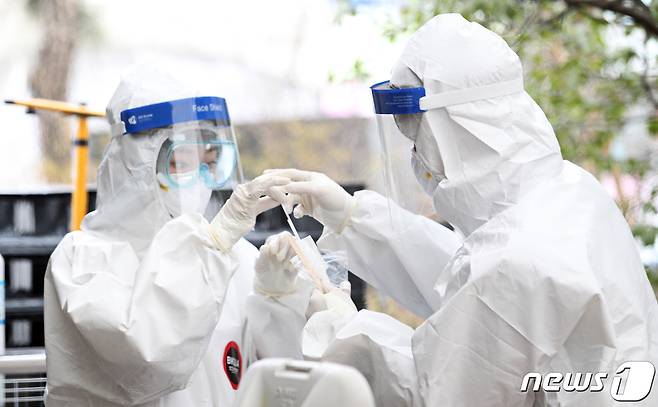 신종 코로나바이러스 감염증(코로나19) 국내 첫 감염자가 발생한지 1년째인 20일 서울 동작구 보건소 코로나19 선별진료소에서 의료진이 검체 채취를 하고 있다. (동작구청 제공) 2021.1.20/뉴스1