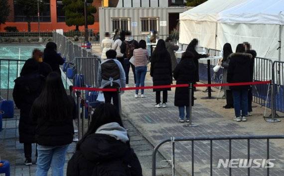 부산 부산진구 놀이마루 운동장에 마련된 신종 코로나바이러스 감염증(코로나19) 임시선별검사소를 찾은 시민들이 22일 오후 진단검사를 받기 위해 길게 줄을 선 채 차례를 기다리고 있다. /사진=뉴시스