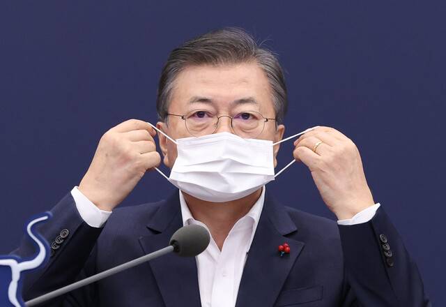 문재인 대통령이 25일 오후 청와대에서 열린 보건복지부·식품의약품안전처·질병관리청 2021년 업무보고에서 발언을 마친 뒤 마스크를 쓰고 있다. 연합뉴스