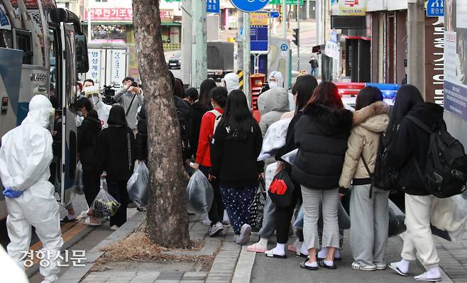 버스 탑승하는 확진자들 지난 24일 코로나19 신규 확진자가 127명 발생한 대전시 중구 대흥동 IEM국제학교에서 25일 확진자들이 건물에서 나와 버스와 구급차를 타고 있다.  이준헌 기자 ifwedont@kyunghyang.com